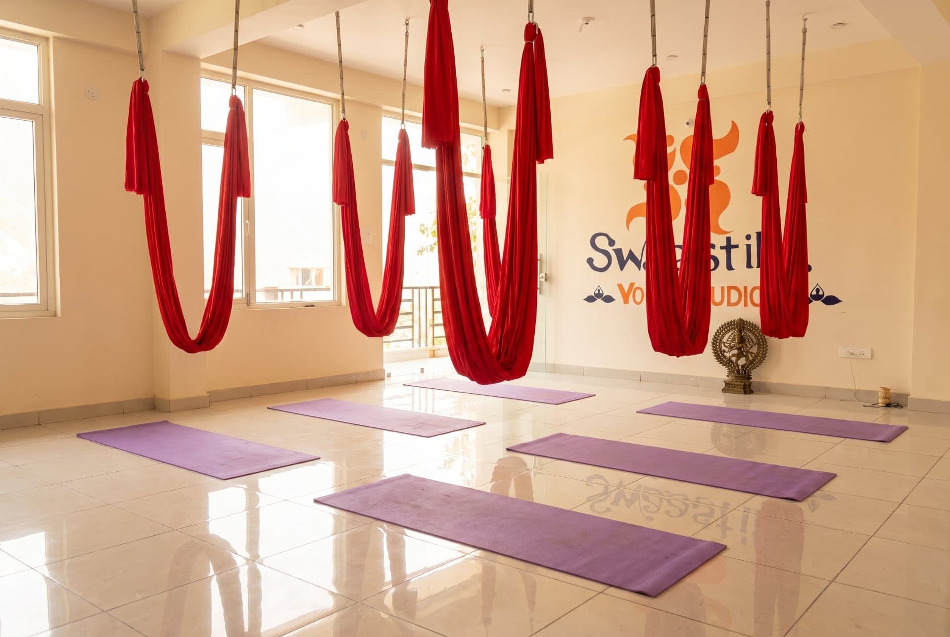 A studio in Rishikesh with rows of aerial hammocks hanging from the ceiling rig